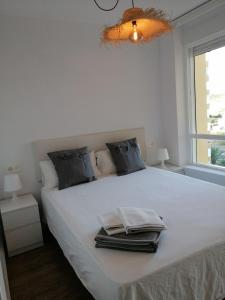 - une chambre avec un lit blanc et des serviettes dans l'établissement HH Apartamento Algarrobo costa, à Algarrobo-Costa