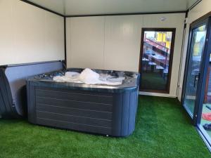 a hot tub in a room with green grass at Rezydencja Kwiatano - Basen & Jacuzzi & Sauna & Plac Zabaw in Grzybowo