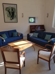 salon z niebieską kanapą i stołem w obiekcie VILLA CHAMPAGNE w mieście Colombey-les-deux-Églises