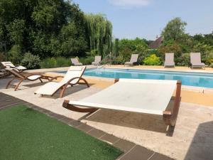 a table and chairs next to a swimming pool at Au Soleil d'Or in Pontaubert