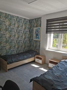 um quarto com 2 camas e papel de parede floral em Reda apartments em Lublin