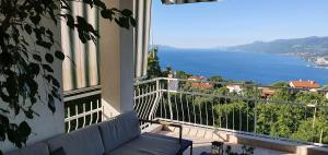 a balcony with a couch and a view of the ocean at Apartments Frlan in Kastav