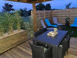 a patio with a table and chairs on a deck at Gîte l'instant T in Thorigny