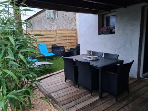 a black table and chairs on a wooden deck at Gîte l'instant T in Thorigny +6 photos