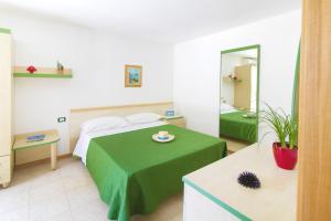 Habitación de hotel con cama y espejo en Vaia Residence, en Torre dell'Orso
