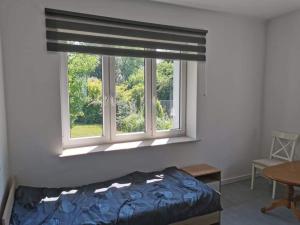 a bedroom with a window with a bed and a table at Reda apartments in Lublin