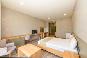 a bedroom with a bed and a desk and a tv at Agora Suites in Esenyurt
