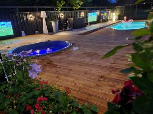 a backyard deck with a hot tub and a tv at Exclusive villa Stockholm in Stockholm