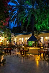 un restaurante con una palmera, mesas y sillas en Route Hotel Kaleici - Adult Only (12+) en Antalya