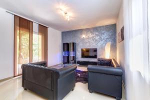 a living room with two leather chairs and a television at Casa Verde in Čunski