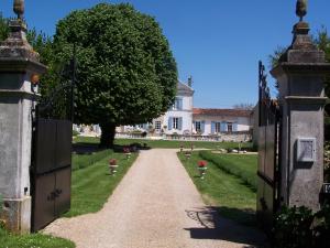uma entrada que leva a uma casa com uma árvore em Le Four à Pain em Saint-Jean-dʼAngély