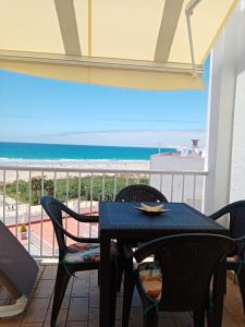 una mesa y sillas en un balcón con vistas a la playa en Apartamento Santa Barbara, en Conil de la Frontera