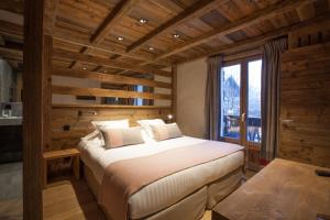 a bedroom with a bed in a room with a window at Au Coin Du Feu in Megève
