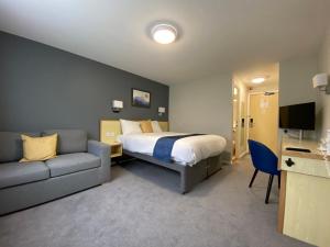 a hotel room with a bed and a couch at Days Inn Hotel Sedgemoor in Rooks Bridge