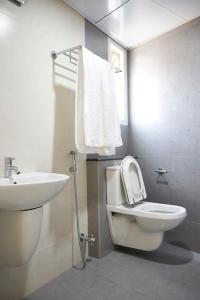 a bathroom with a white toilet and a sink at Srivar Hotels in Guruvāyūr