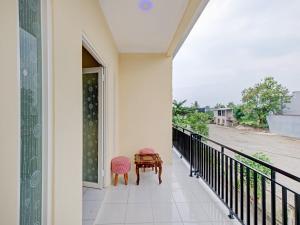 a table and two chairs on a balcony at Urbanview Hotel Jogja City Mall in Yogyakarta
