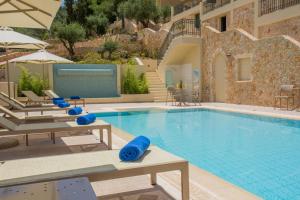 阿爾戈斯托利的住宿－Ionian Vista Villas，一个带椅子和遮阳伞的大型游泳池