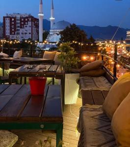 uma varanda com sofás e uma mesa e vista para a cidade em The Rooftop Hostel em Shkodër