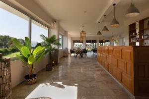 a large living room with a table and some plants at Arion Hotel in Kolymvari