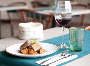 a plate of food and a glass of wine on a table at Casa Rico de Medín in O Pino 