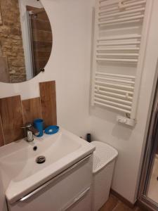 y baño con lavabo blanco y espejo. en Le Delax en Mondeville