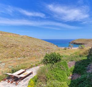 a group of benches sitting on a hill next to the ocean at Agelos Beachfront Villa in Korissia