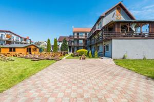 a large house with a brick driveway in front of it at Villa Baltic Karwia in Karwia