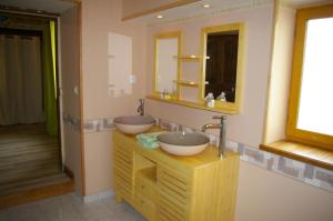 La salle de bains est pourvue de 2 lavabos et d'un miroir. dans l'établissement Gite au Chalet, à Laferté-sur-Aube