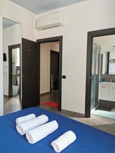 a room with three towels on a blue bed at Porta Romana in Viterbo