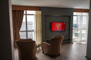 a living room with two chairs and a television at Pasaport Pier Hotel in İzmir
