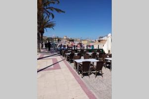 una fila de mesas y sillas en una acera en Campello Alicante Playa, en El Campello