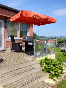 eine Terrasse mit einem Sonnenschirm, einem Tisch und Stühlen in der Unterkunft Ferienhaus am Osterberg in Quedlinburg