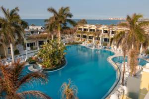einen Blick über einen großen Pool mit Palmen in der Unterkunft Paradise Inn Beach Resort in Alexandria