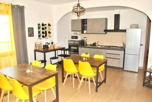 a kitchen and dining room with yellow chairs and tables at Verba Mundi Guest House in Olbia +26 photos