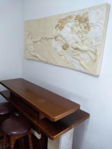 ein Gemälde, das an einer Wand über einem Holztisch hängt in der Unterkunft Alto Aguieira in Viseu
