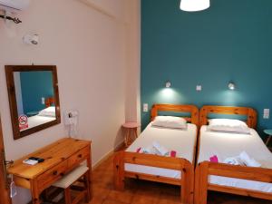 a bedroom with two beds and a mirror at Perdika Mare Guesthouse in Perdika