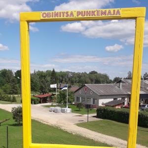 a yellow picture frame in front of a house at Obinitsa Puhkemaja in Obinitsa