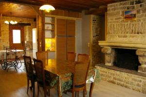 a dining room with a table and a fireplace at Gite au Chalet in Laferté-sur-Aube