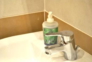 a bathroom sink with a bottle of soap on it at Verba Mundi Guest House in Olbia