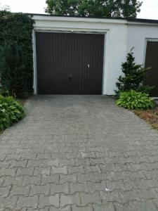 una entrada que conduce a un garaje con puerta de garaje en Apartament Assolato, en Władysławowo