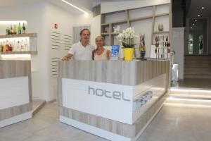 a man and woman standing behind a counter in a store at Hotel Madrid in Rimini