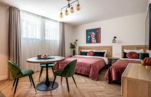 a bedroom with two beds and a table and chairs at Smėlynas Boutique & SPA in Palanga