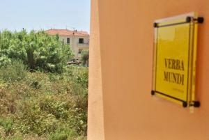 a yellow sign on the side of a building at Verba Mundi Guest House in Olbia