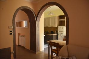 una cocina con un arco en un comedor con mesa en B&B Il Cuore del Borgo, en Papasidero