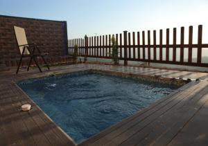 a swimming pool on a deck with a fence at Dar Gerasa chalets - شاليهات دار جراسا in Jerash