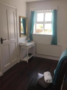 a bathroom with a sink and a mirror and a window at Toomullin House Accommodation in Doolin