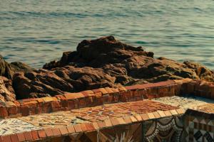 a large pile of rocks next to the water at Hotel la Ponche in Saint-Tropez