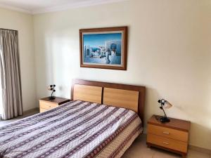 1 dormitorio con 1 cama y una foto en la pared en Varandas do Sol, en Portimão