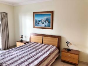 um quarto com uma cama e um quadro na parede em Varandas do Sol em Portimão