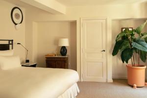 a bedroom with a white bed and a potted plant at Hotel la Ponche in Saint-Tropez